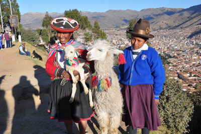 Locals pose with alpacas near Machu Picchu.