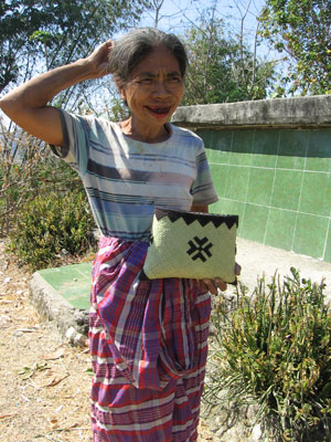 This lovely, betel-chewing lady, her lips stained red, offered a small basket for sale.