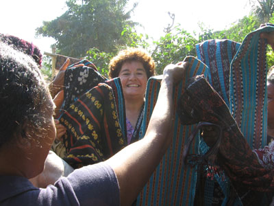 “Help me! Help me!” cries Esther Perica  surrounded by enthusiastic women selling weavings in Sikka, Flores. Photo by Joan Cockell