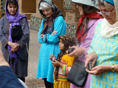 A tour member and (center) Bune Primack, wearing clothes they bought in Iran, speaking with an Iranian girl. Photo: Primack