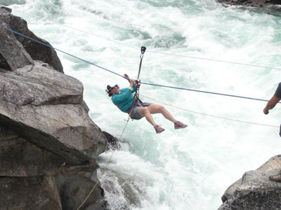 Marlene enjoying the Tyrolean traverse over the Class VI Zeta rapid.