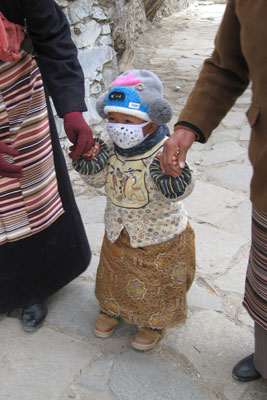 The cutest pilgrim in Shigatse, Tibet. The masks are worn because it is so cold. Photo: Florence Drake