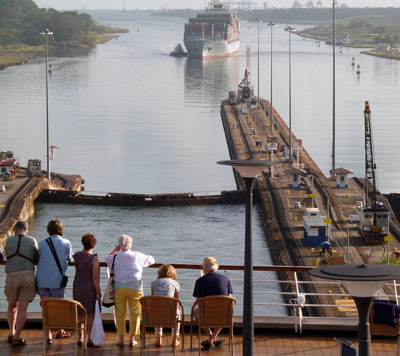Passengers observe the Panama Canal crossing from the ship’s deck.