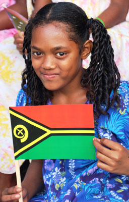 A Vanuatu girl displays the national flag (which features a boar’s curved tooth) on Independence Day. Photos by Lew Toulmin