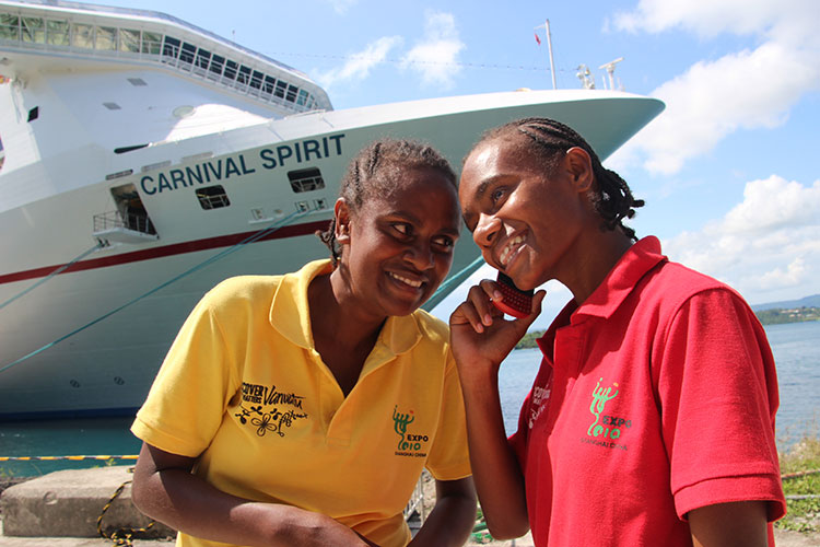 Local girls chatting on the phone in front of a Carnival Cruise Lines ship in Port Vila. Photos by Lew Toulmin