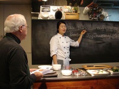 John Scott taking instruction from Chef Hyejin Kim at the O’ngo Food Communications cooking school in Seoul, Korea. Photo by Sandra Scott