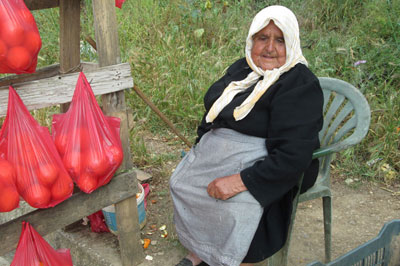 A village woman selling oranges at a roadside hut in western Crete.