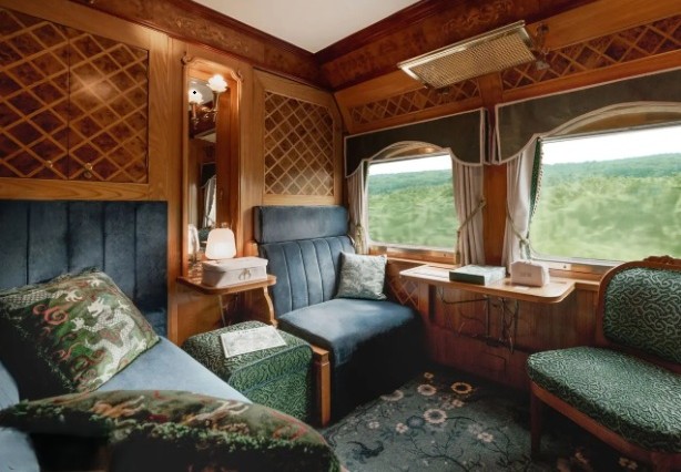 Elegant wood-trimmed train car with views of lush green foliage