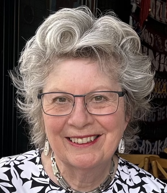 Woman with white hair and glasses