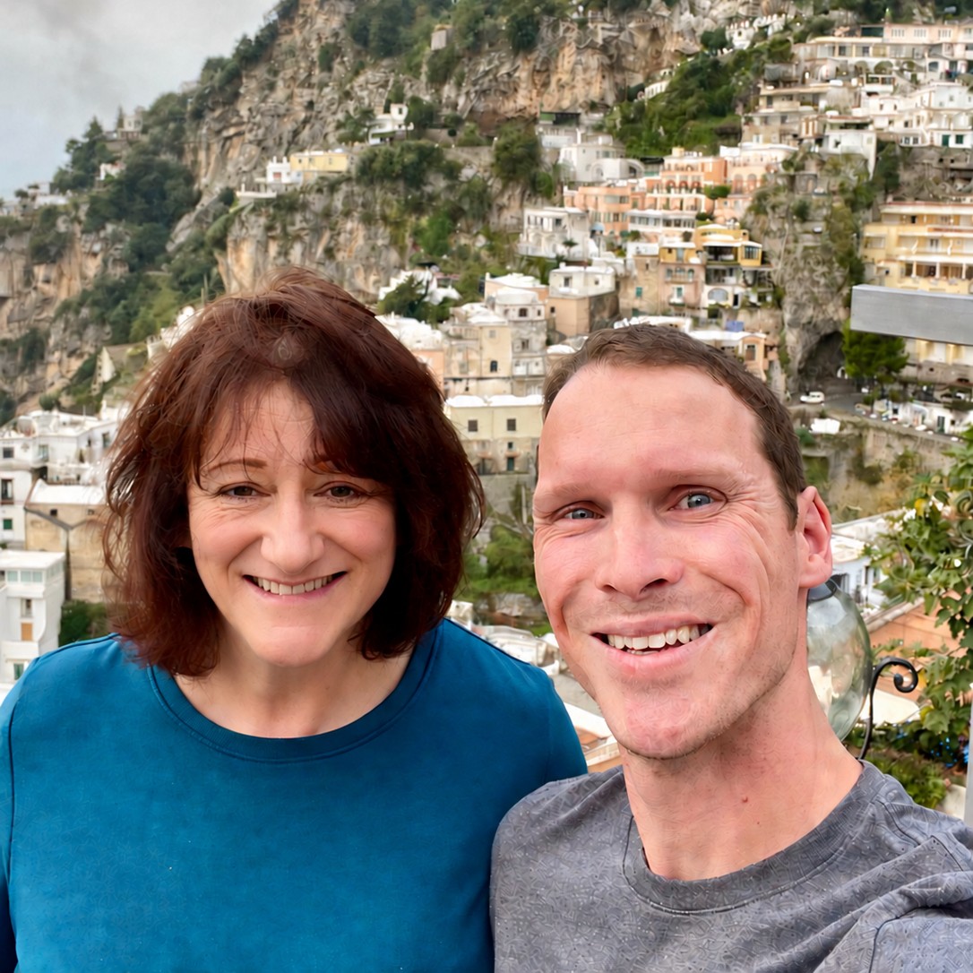 Woman and man with European hillside town behind them