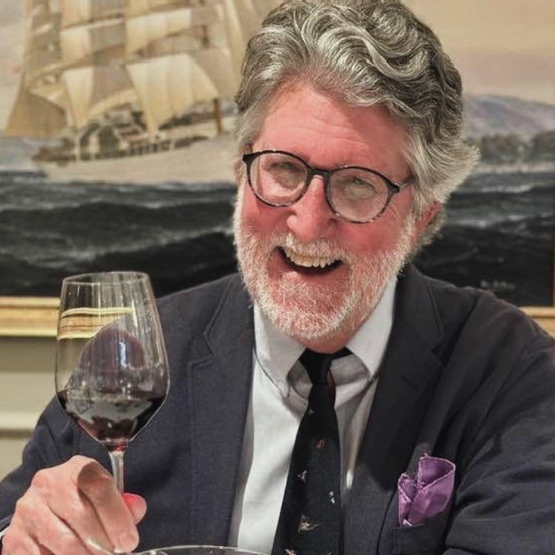 man with glasses holding a wine glass