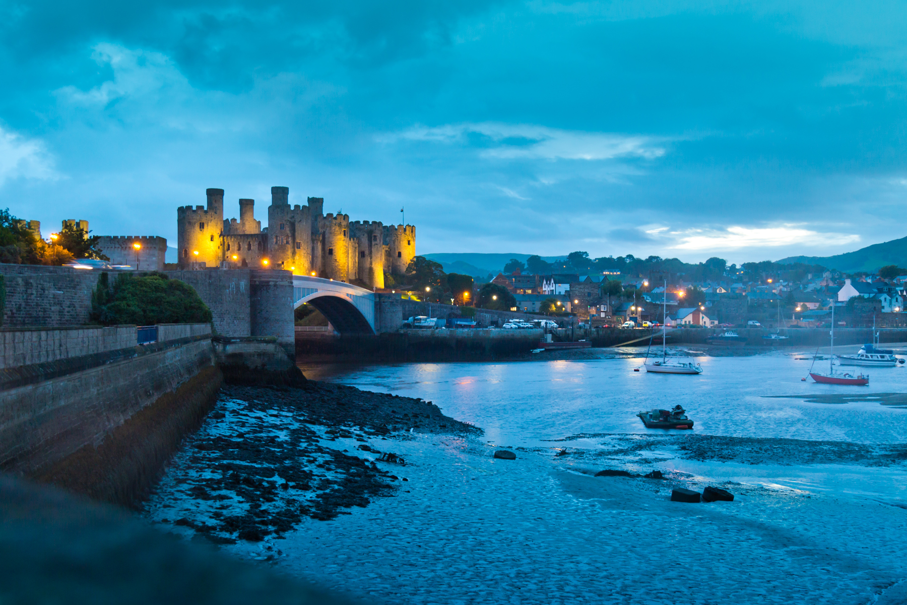 A castle on the water lit against a night sky