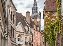 The 15th-century Tour de l’Horloge (Clock Tower) peeks above medieval buildings in the Old Town of Auxerre, France.