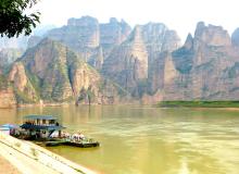 Binglingsi Shiku, aka Thousand Buddha Caves, with sandstone peaks rising above the Liujiaxia Reservoir.