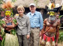 Jean and Fred DeVinney flanked by tribal members at the Tumbuna Sing-Sing in Papua New Guinea. 