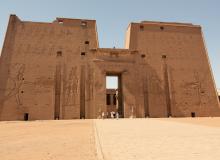 Enormous carved walls and the doorless entrance dwarf visitors to the Temple of Horus at Edfu.