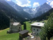 Driving through the mountains of northern Italy on a beautiful sunny day in August 2018, I came across this quaint mountain village with a glacier in the background. Photo by Liz Fischer