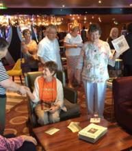 Karen Wagner (right) shared copies of ITN with passengers on the Eurodam.