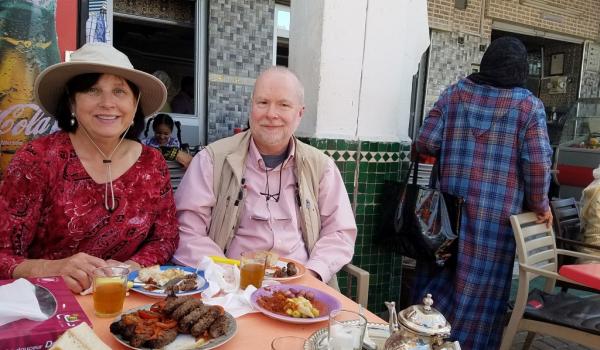 Paula Owens and husband, Stephen Addison, enjoying a kebab lunch outside a small café in Moulay Idriss, Morocco. Photo by guide Abdellah El Harras