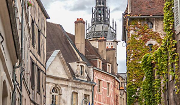 The 15th-century Tour de l’Horloge (Clock Tower) peeks above medieval buildings in the Old Town of Auxerre, France.