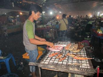 A vendor barbecues fish at Kota Kinabalu’s night market.