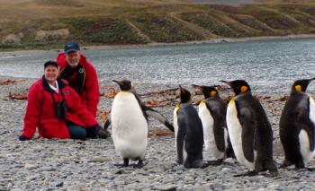Linda and Peter Beuret on South Georgia Island with king penguins