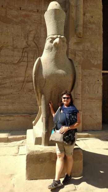 Debi Shank with a statue of Horus at the Temple of Horus in Edfu.