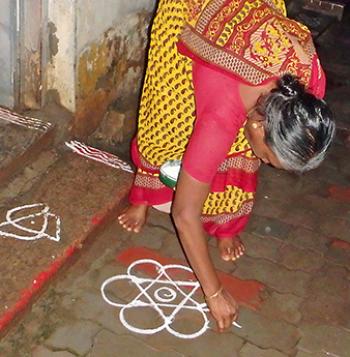 A lady drawing a kolam on her front step — Madurai. Photo by Sandra Hicks