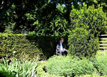 A local found a quiet spot in the garden to read a newspaper.