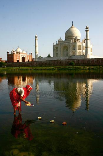 A woman making an offering to the Yamuna River, near the Taj Mahal.