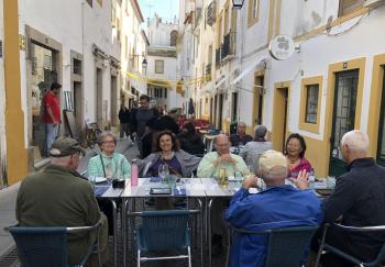 Tour leader Carla (center) and tour members dining in the middle of a street in Évora, Portugal, in October 2019.