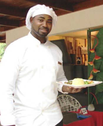 Chef Dwayne of <b><i>Ciao Jamaica</i></b> with a plate of Jamaican Goat Curry — Negril. Photos by Sandra Scott