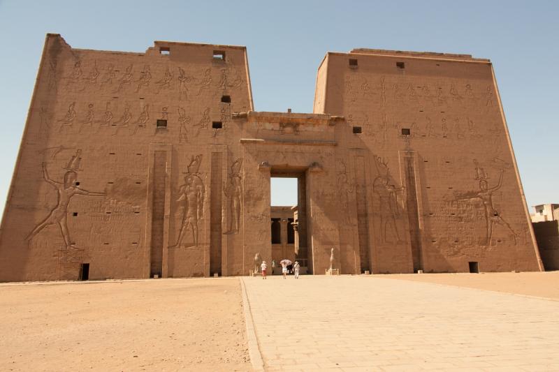 Enormous carved walls and the doorless entrance dwarf visitors to the Temple of Horus at Edfu.